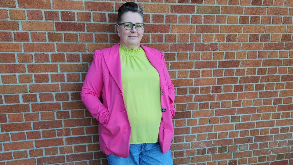 Leanne standing against a brick wall